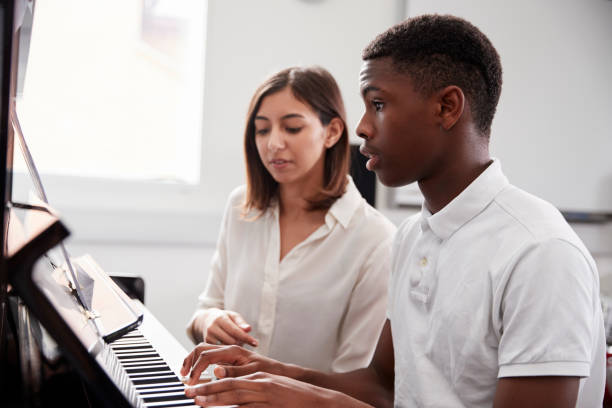 Aprende a tocar piano rápido con este atajo efectivo 10 masculino estudiante con maestro tocando el piano en la leccion de musica